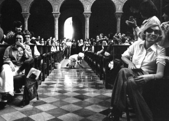 Participantes en las Jornades Catalanes de la Dona de 1976, con una actriz fregando el suelo. / Foto: Pilar Aymerich